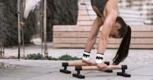 Women is doing a handstand on parallettes