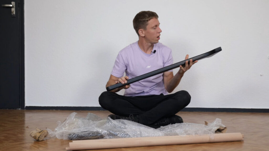 Jelle inspecting the unpacked contents of the package the Gorletic Front Lever Bar arrived in.