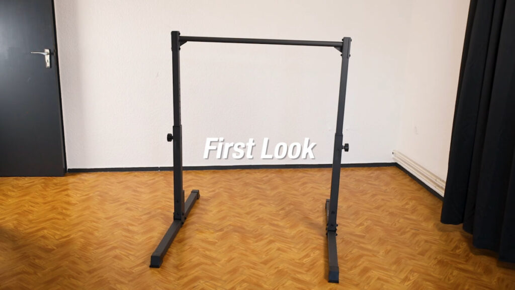 The Gravity Fitness Static Bar standing at its heighest setting in a room with white walls, wood-colored floor and black door.