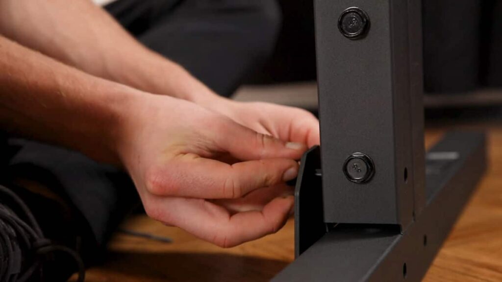 A connector plate being attached to a foot and an vertical post of the Gravity Fitness Static Bar to tie them together securely using bolts.