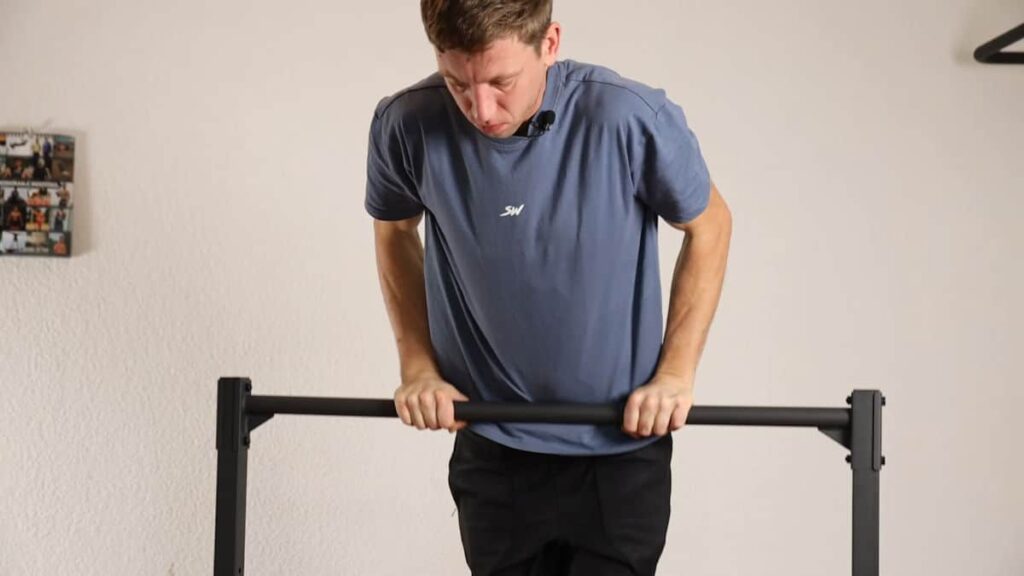 Man in blue tshirt performing a straight bar dip on the Gravity Fitness Static Bar.