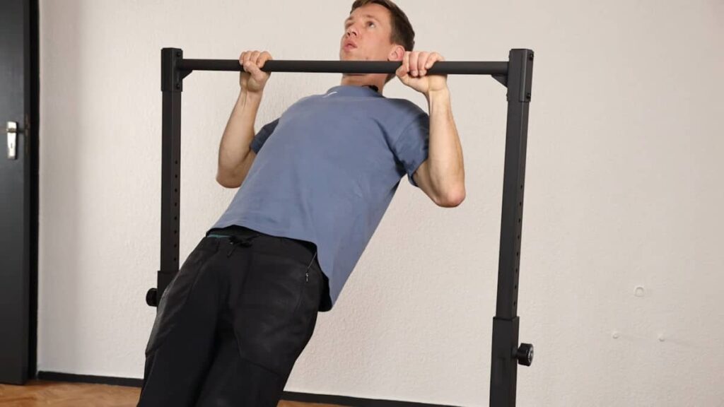 Man in blue tshirt performing a body row under the Gravity Fitness Static Bar.