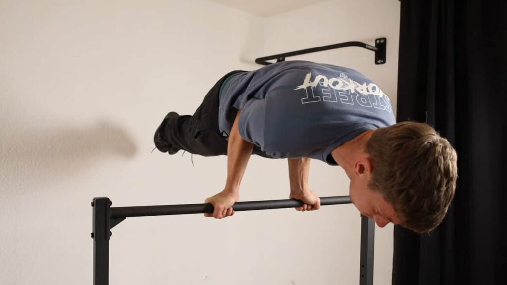 Man in blue shirt performing a straight Planche on the Gravity Fitness Static Bar.