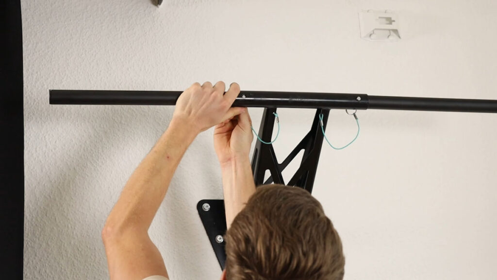 Man attaching the left straight bar on the Mobile Pullup and Dip Bar as an alternative to the multi-pronged bar.