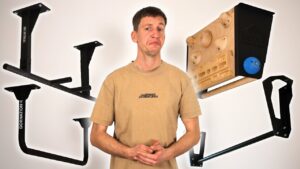Man in beige shirt standing between several Ceiling Pull-Up Bars.