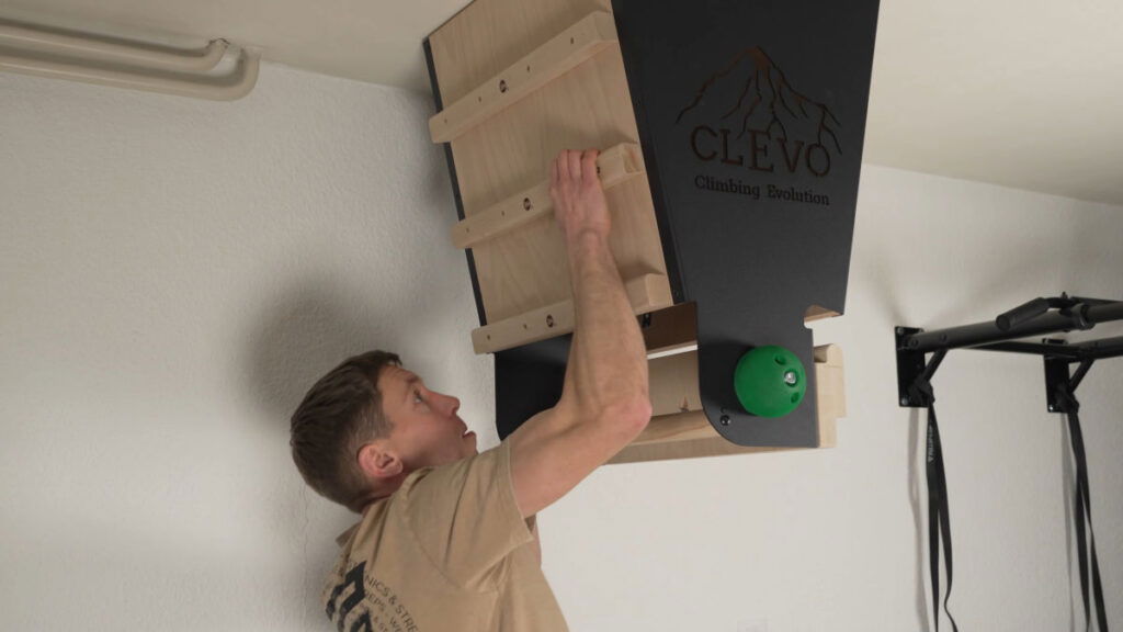 Man in beige shirt climbing up the campus rungs on the CLEVO Ceiling XL.