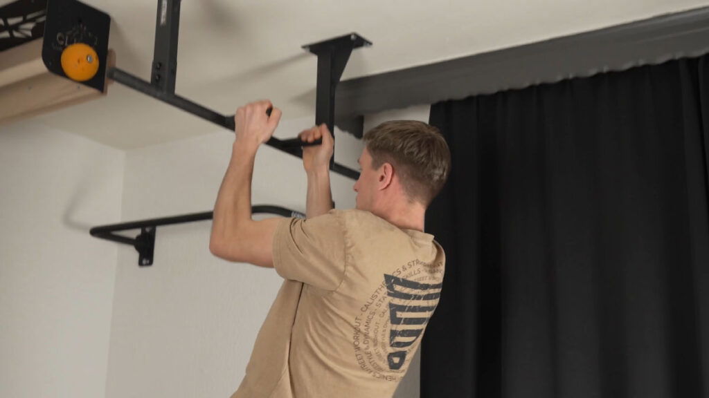 Man in beige shirt performing a neutral-grip Pull-Up on the Pullup & Dip Ceiling Pull-Up Bar.