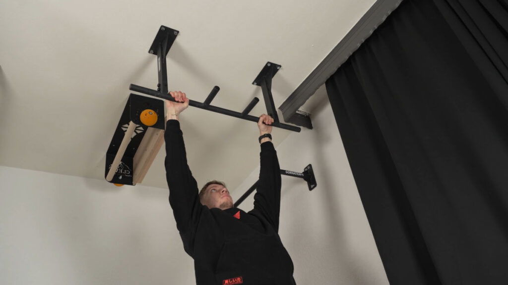 Man in black shirt performing a Pull-Up on the Pullup & Dip Ceiling Pull-Up Bar.