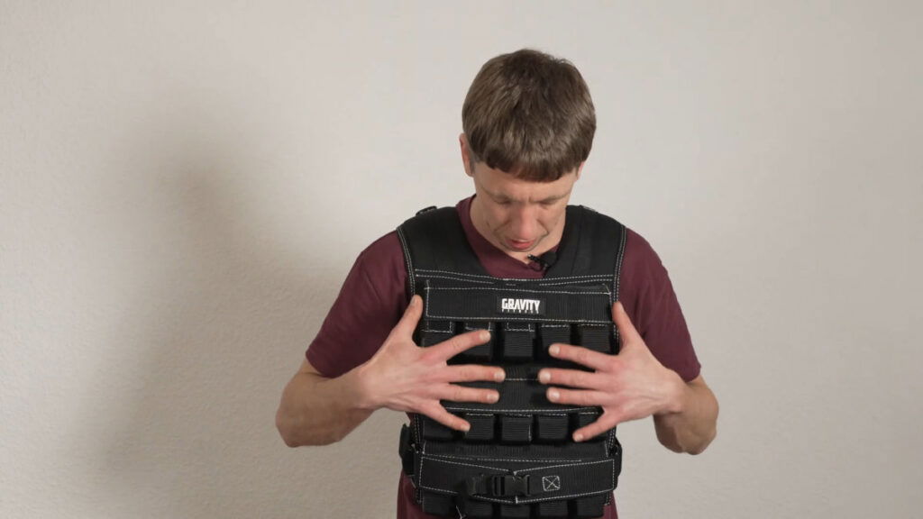 Man in red shirt wearing the 30kg Gravity Fitness Weighted Vest.