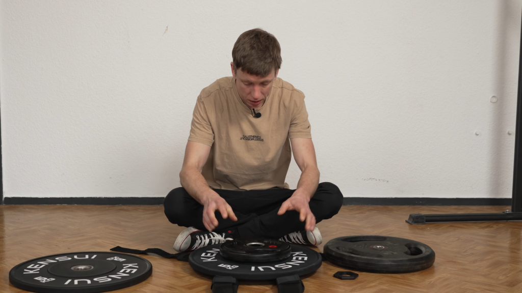 Man trying to fit two thumper plates on his plate loaded vest but noticing the carry thread is too short.