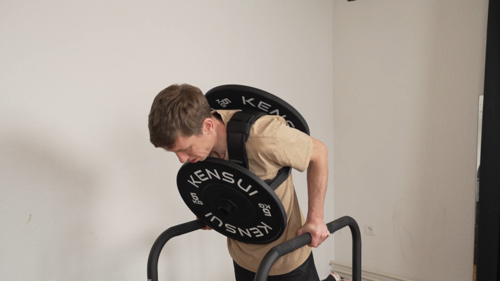 Man attempting a dip while wearing a plate loaded weight vest but finds that the back plate wedges against his elbows.