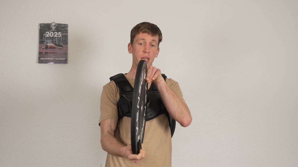 Man showing the thin width of the Kenzui EZ plates that will fit his plate loaded weight vest.