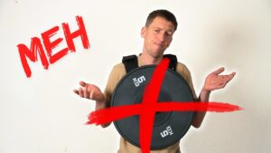 Man wearing a plate loaded weight vest, shrugging his shoulders and hands with a big red X striping through the vest and the word spelling "MEH" beside him.