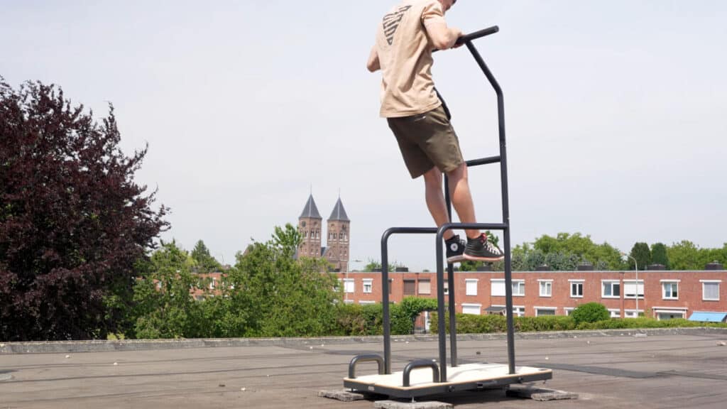 The Fit! Free-Standing Pull-Up Bar threatens to topple when a man in the beige shirt attempts a muscle-up.