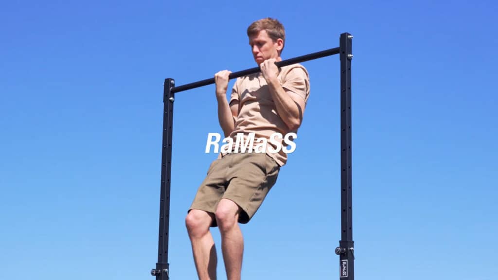 Man in beige shirt doing a chin-up on the RaMaSS Fitness Free-Standing Pull-Up Bar