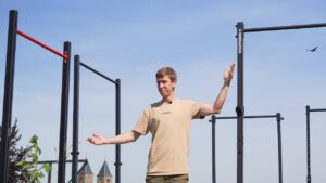 Man in beige shirt standing between various Free-Standing Pull-Up Bars and pointing inquisitively at them.