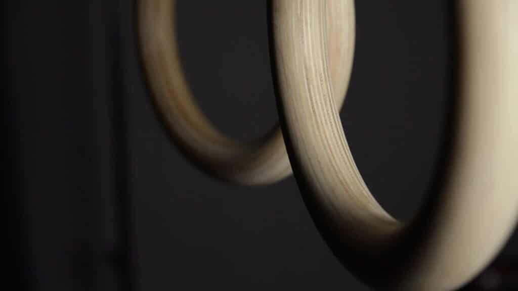Close up of the Gorletic Gymnastic Rings' lower half showing the diameter and wood grain.