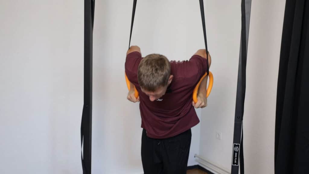Man in purple shirt starting a Muscle-Up on the Nayoya Gymnastic Rings.