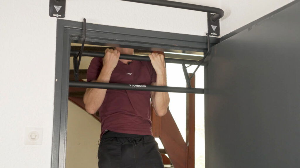 Man in purple shirt doing a Chin-Up on the Gornation Hook-It as his home Pull-Up Bar.