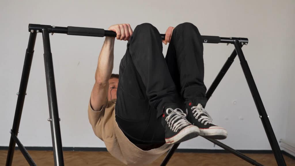 Man performing a back lever on the Khanh Trinh Pull-Up Bar in its lowest setting as a Static Bar.