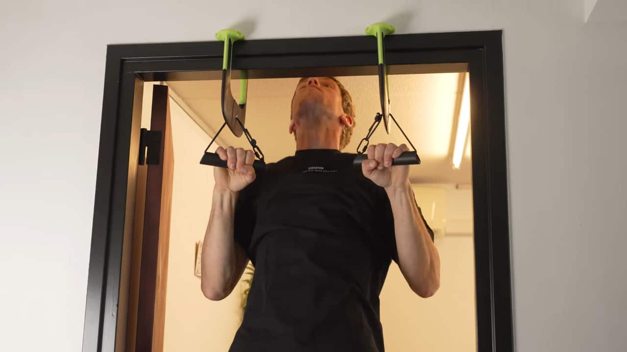 Man performing Pull-ups on the Duonamic Eleviia door pull-up handles.