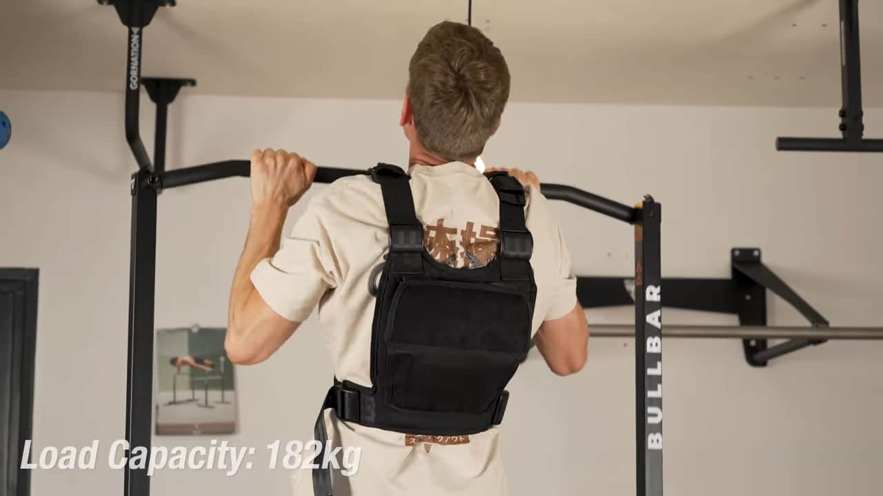 Man wearing a weighted vest doing pull-ups on the bullbar 2.0 foldable pull-up bar.