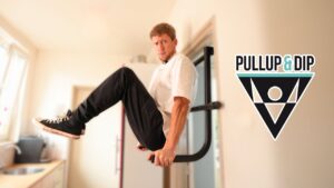 Man in white shirt looking suspiciously at the camera while performing an L-sit on the pullup & dip doorway dip bar.