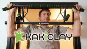 A man hanging from a KAKICLAY Pull-Up Bar and staring questioningly at the viewer.
