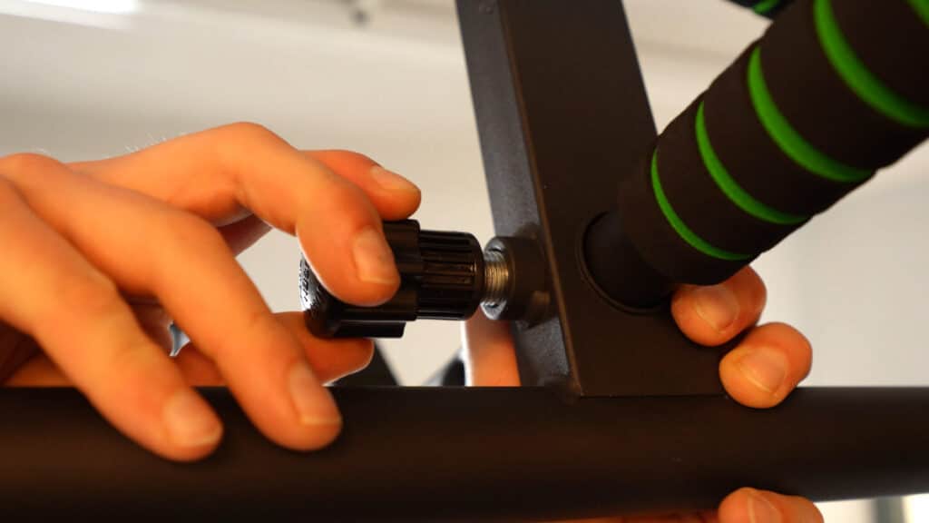 Unscrewing of the knob screw which allows the wall offset to be manipulated on the KAKICLAY Pull-Up Bar Multi Grip.