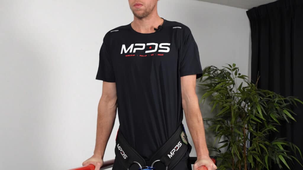 Man in black attire doing weighted dips wearing the MPDS Dip Belt.