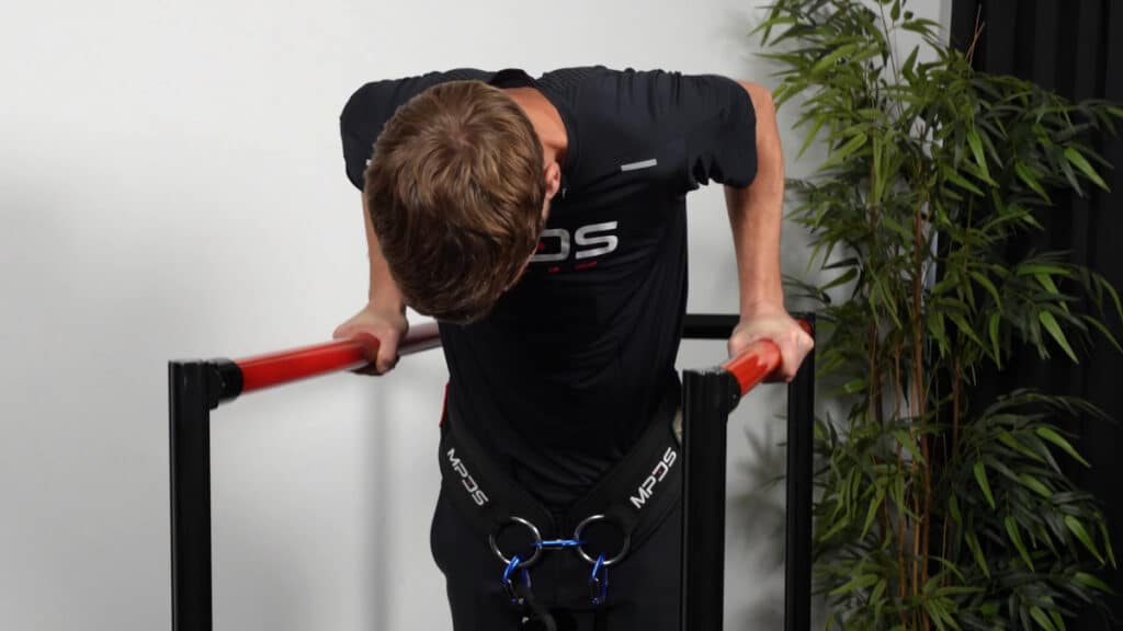 Man in black training attire doing weighted dips wearing the MPDS Dip Belt.