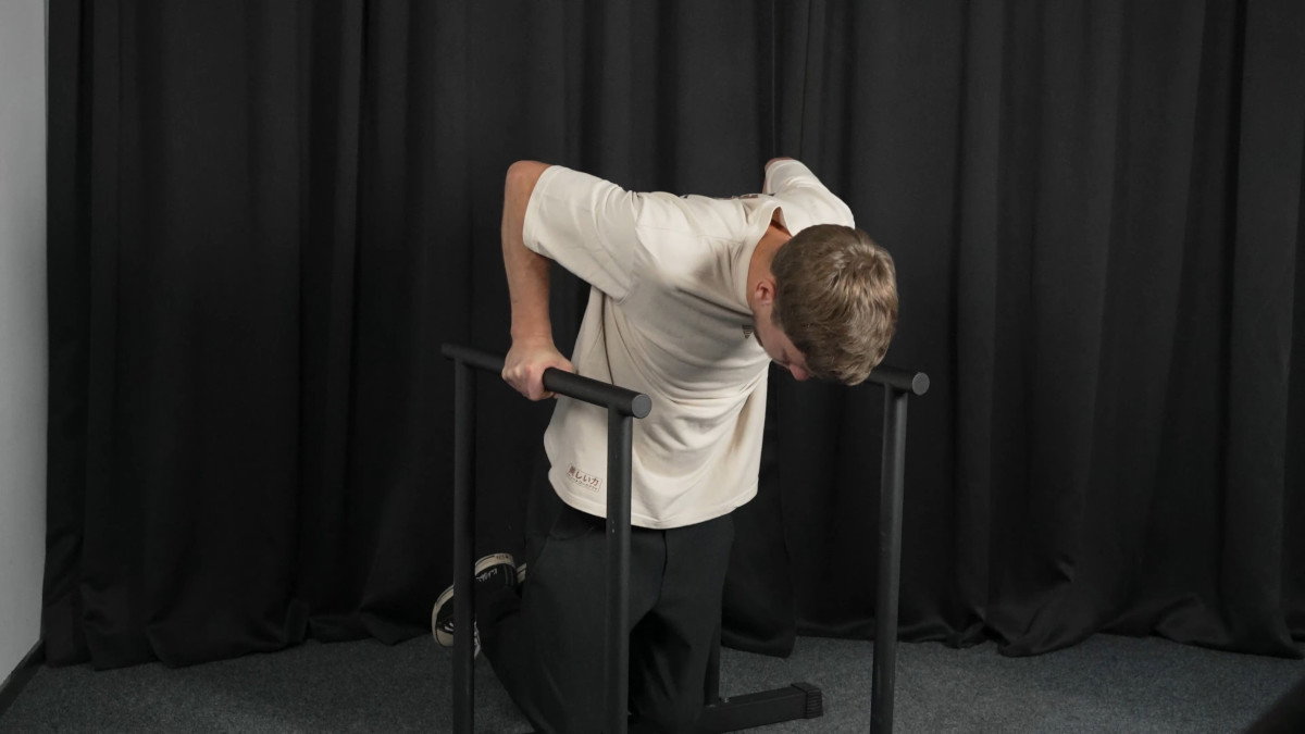 Man in white shirt performing dips on the ramass fitness dip bars.