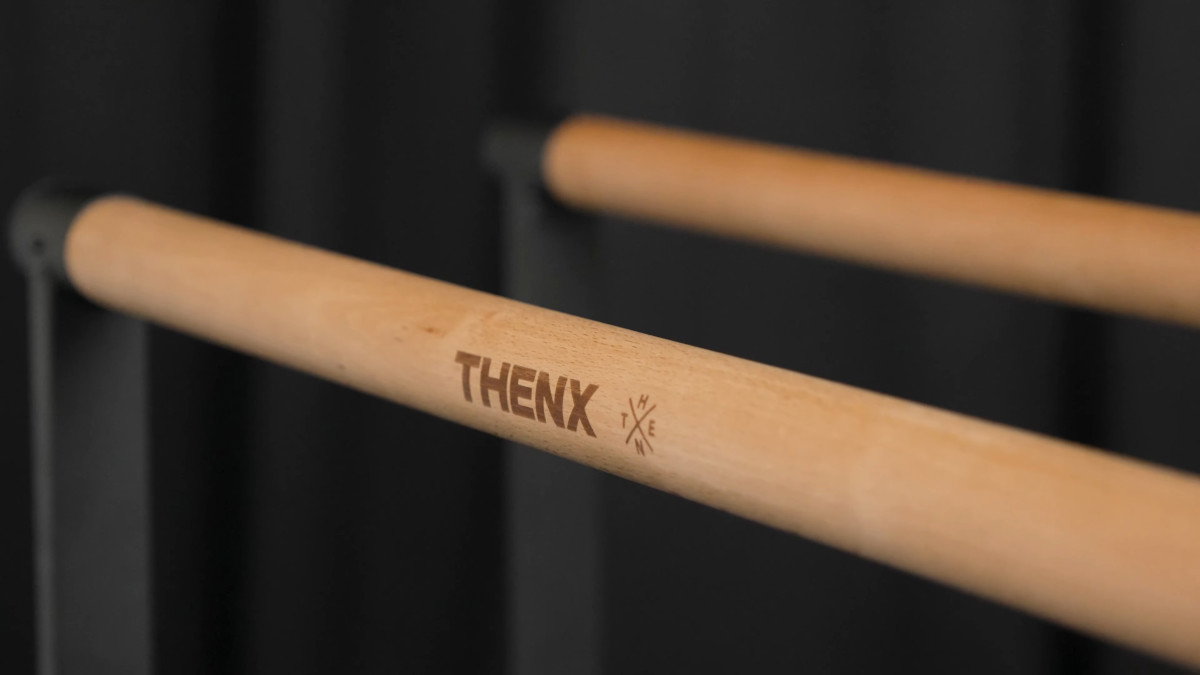 Close up of the thenx dip bar and its satin wooden handles.