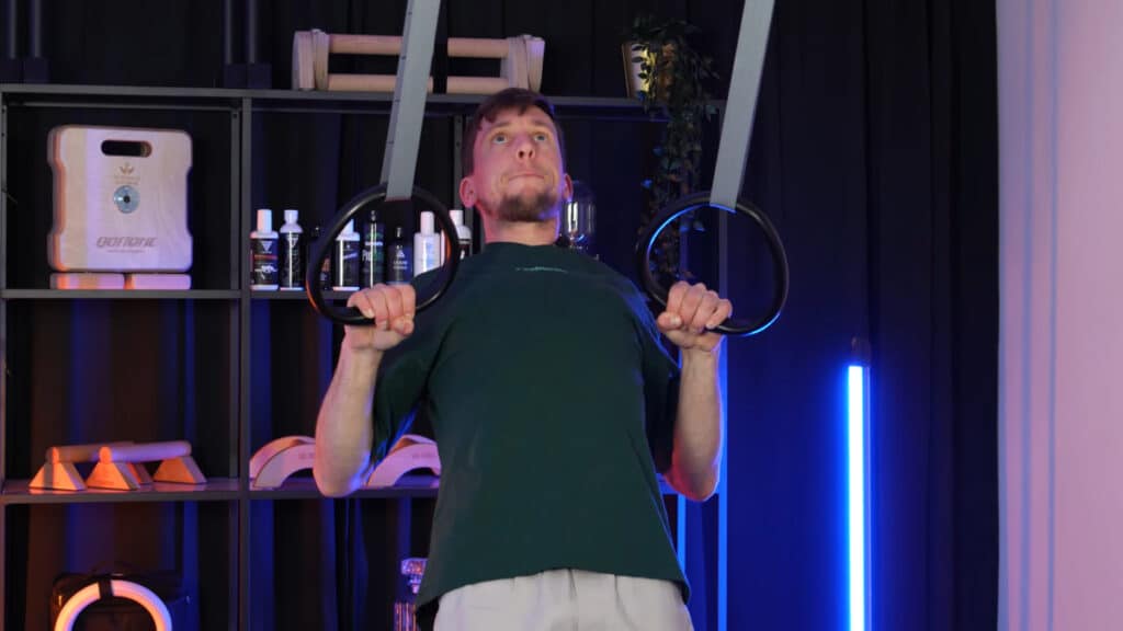 Man in green shirt doing rows on the weightless Marmati Gymnastic Rings.