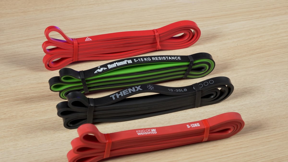 Four light resistance bands side by side by barmania pro, thenx and king of weighted.