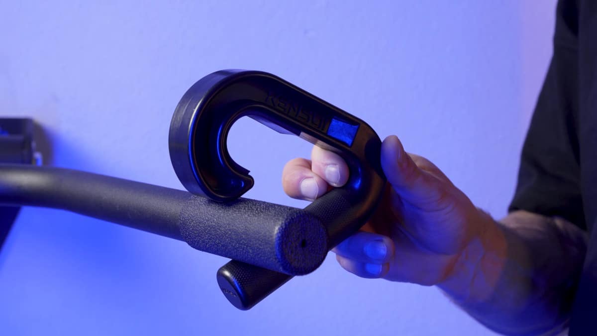 Man attempting to apply the kensui swissies v1 pull-up handles to a bar that is too thick.