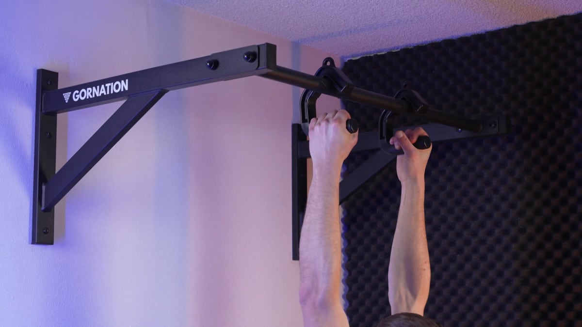 Man doing neutral grip pull-ups with the kensui swissies v2 pull-up handles hooked on a gornation wall pull-up bar.