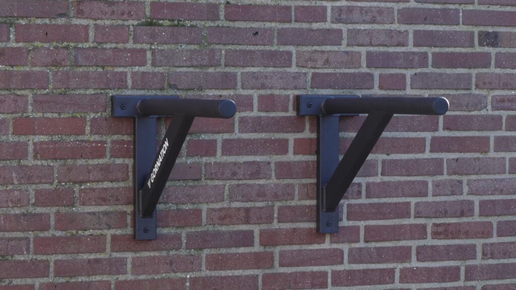 The gornation wall-mounted dip bars fixed to an outside brick wall.
