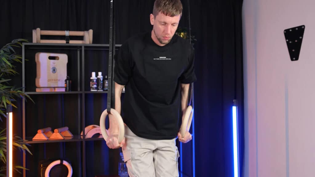 Man in black shirt doing dips on a pair of gravity fitness gymnastic rings.