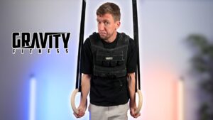 Man doing a muscle-up on the gravity fitness gymnastic rings and looking doubtfully as the viewer.