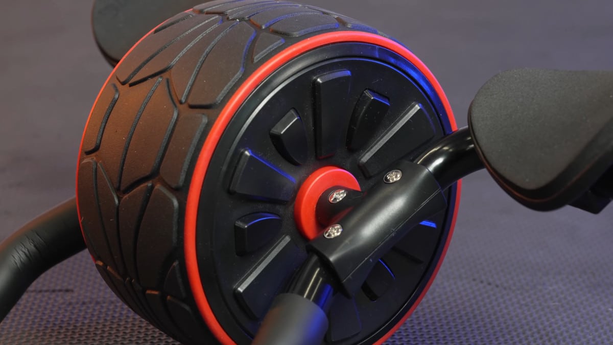 Close side view of the rims of the dmoose ab roller, with the elbow rests in view on either side of the wheel.