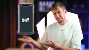 Man in white shirt making a presenting gesture towards a large phone with the freeletics app logo displayed on it.