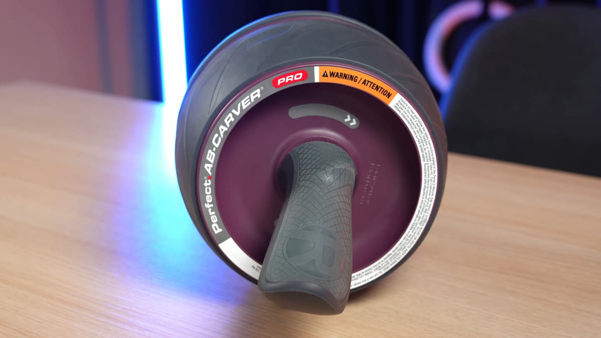 Size view of the Perfect Fitness Ab Carver Pro showing the turning direction of the wheel clearly indicated on the rim.