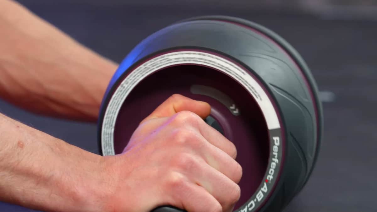 Man losing grip of the Perfect Fitness Ab Carver Pro, causing the wheel to spin rapidly.