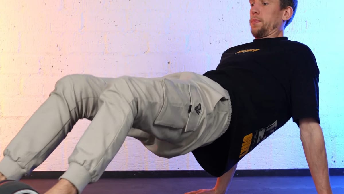 Man attempting to do leg exercises on the Perfect Fitness Ab Carver Pro but the wheel unwinding on him because of the lack of floor pressure.