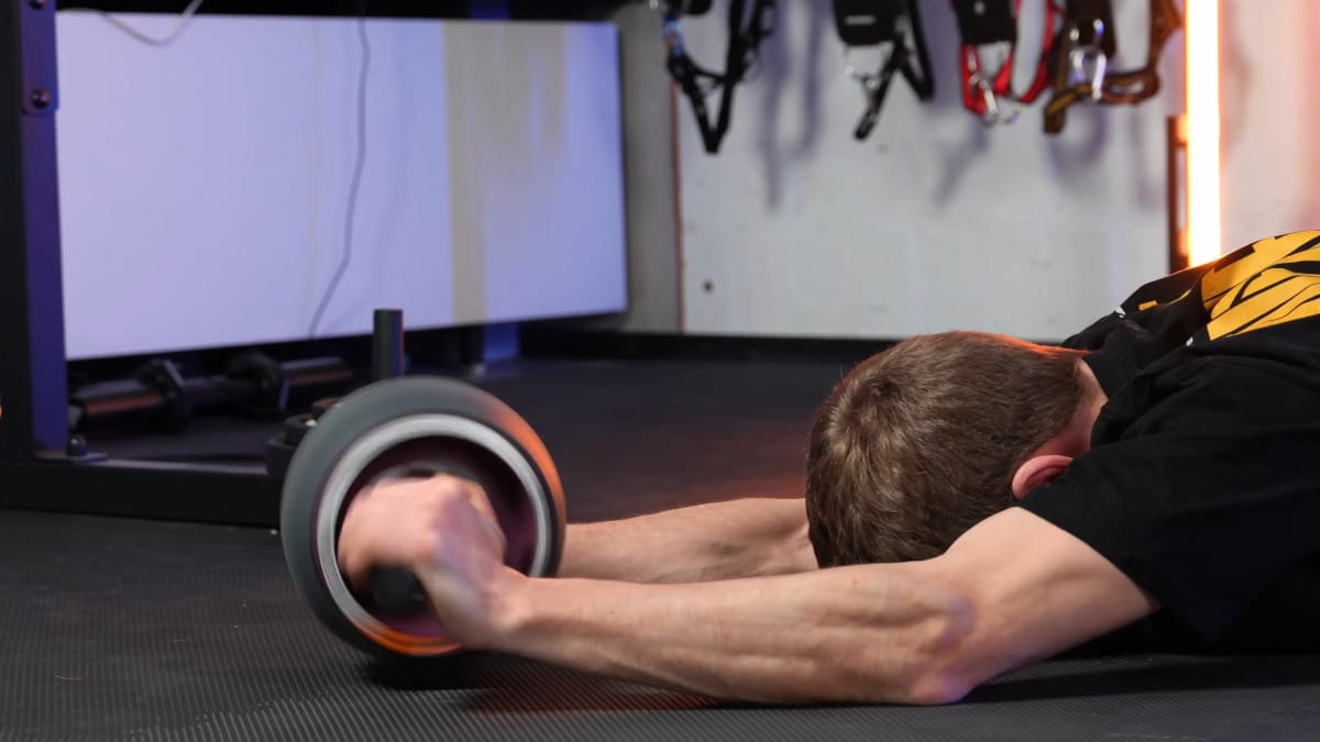 Man losing grip on the Perfect Fitness Ab Carver Pro, causing the wheel to spin rapidly as the internal spring unwinds and leaving him fall to the floor.