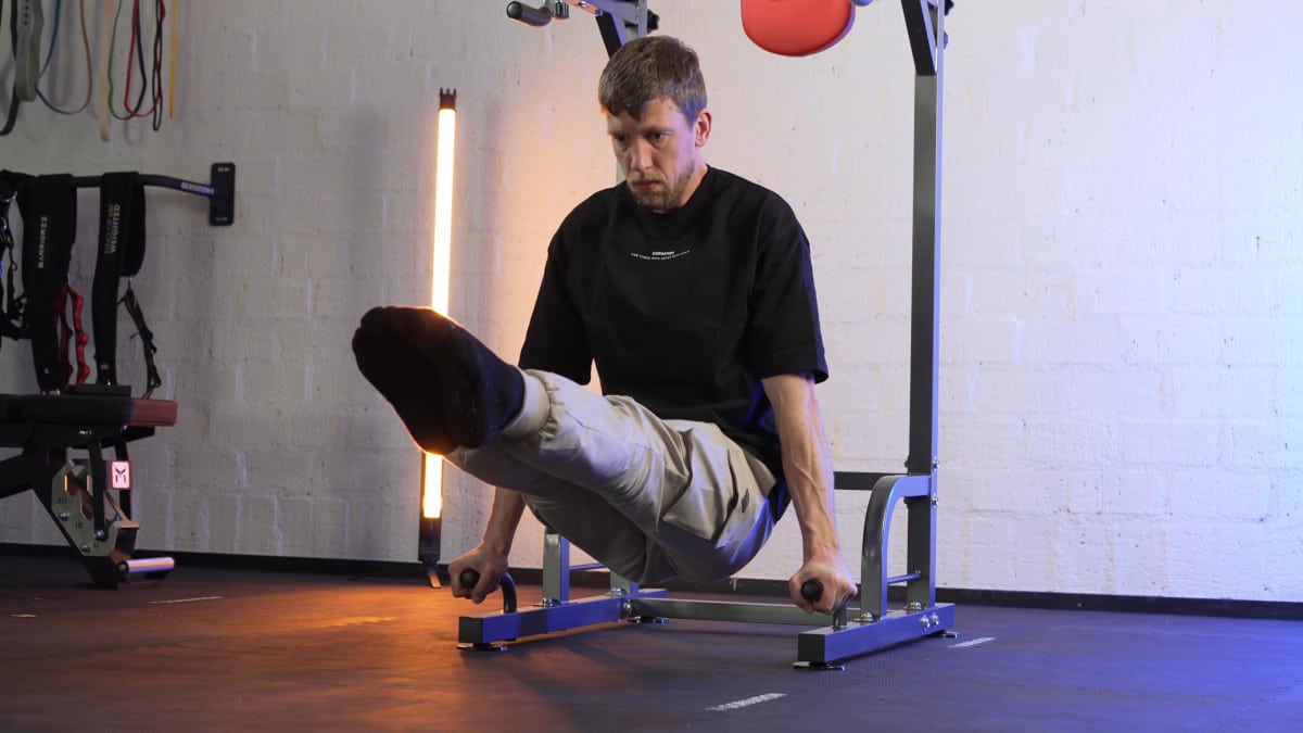 Man doing L-sits on the relife power tower's push-up handles.