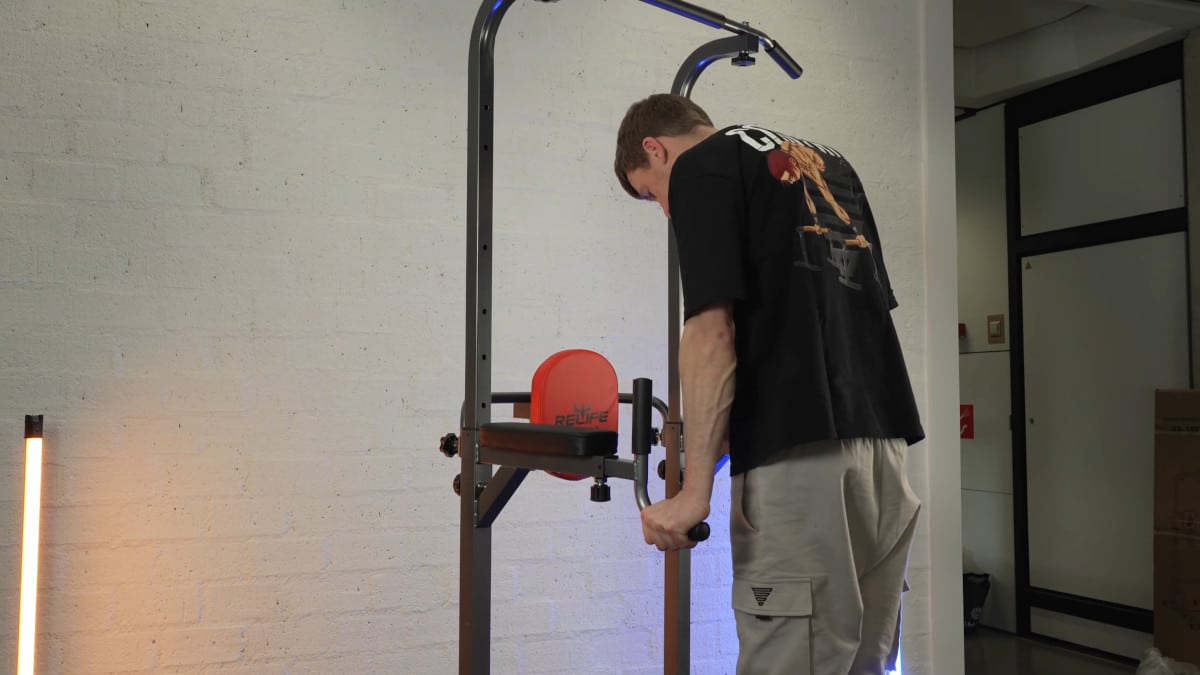 Man in black shirt doing dips on the relife power tower's dip handles.