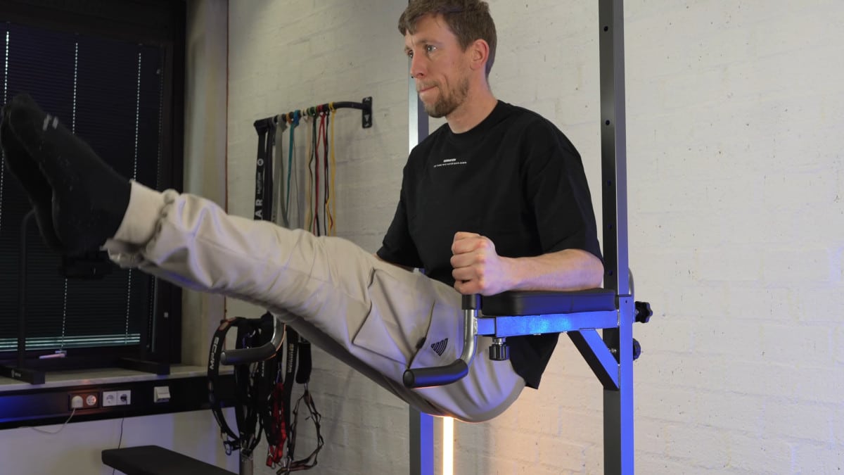 Man in black shirt doing ab exercises on the relife power tower's elbow rests and backrest.