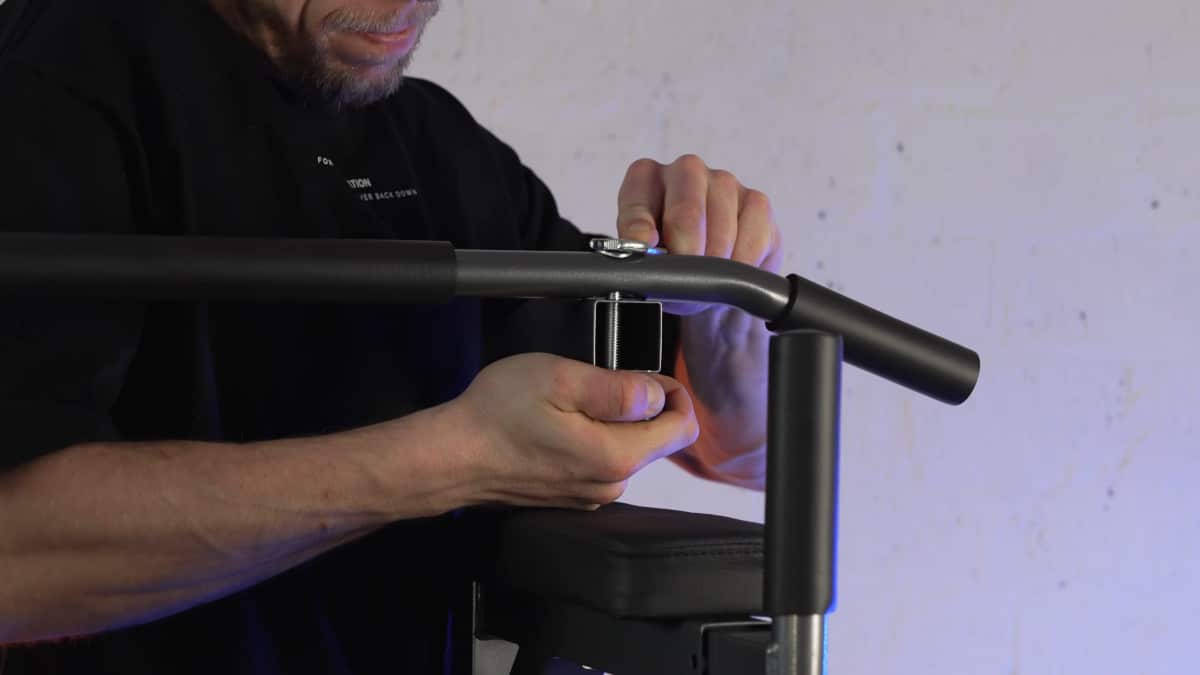 Man assembling the relife power tower by fastening the top bar to the vertical legs with nuts and bolts using a spanner.